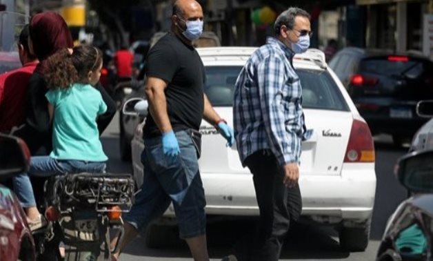 FILE - Men wearing protective face masks walk in downtown Cairo, amidst concerns about the spread of the coronavirus disease (COVID-19), Egypt, May 2, 2020. REUTERS/Mohamed Abd El Ghany
