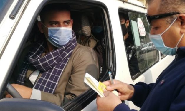 Officer checks license of driver in Cairo in January - Youm7