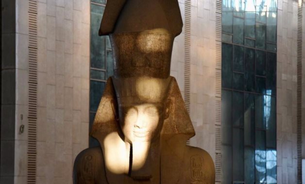 File: The rays of the rising sun now shine on the face of the statue of King Ramesses II standing tall in the Grand Hall of GEM.