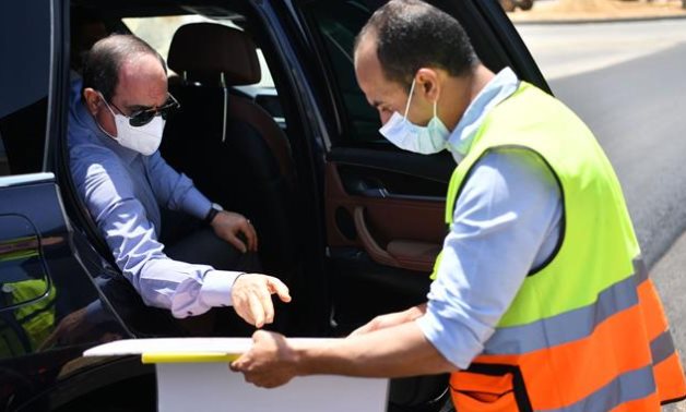 President Abdel Fattah El Sisi listens to an employee at one of road development projects eastern Cairo- press photo