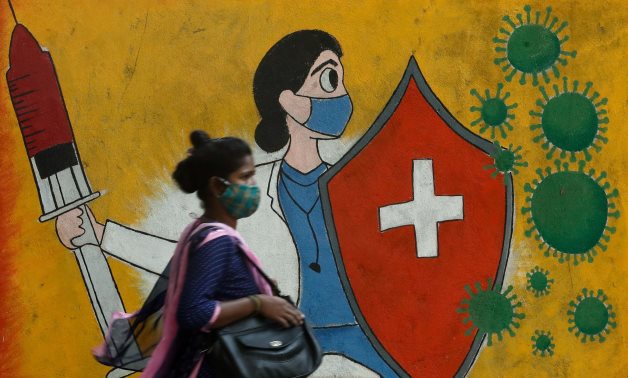 File- A woman walks past a graffiti on a street, amidst the spread of the coronavirus disease (COVID-19) in Mumbai, India, May 10, 2021. REUTERS/Francis Mascarenhas