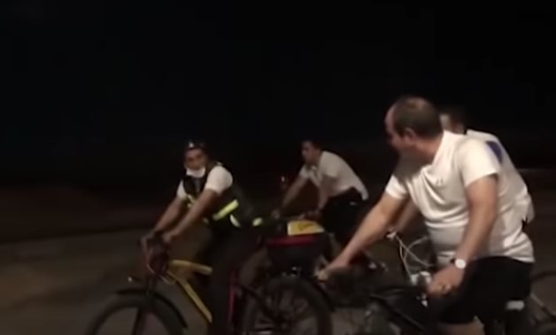 President Sisi drives his bicycle and listens to one of the military conscripts- a screenshot of a video.