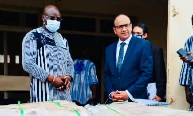 Burkinabe minister of health (l) and Egyptian Ambassador Ibrahim al-Khouly posing in Ouagadougou with shipments of medical aid provided by Egypt in August 2021. Press Photo