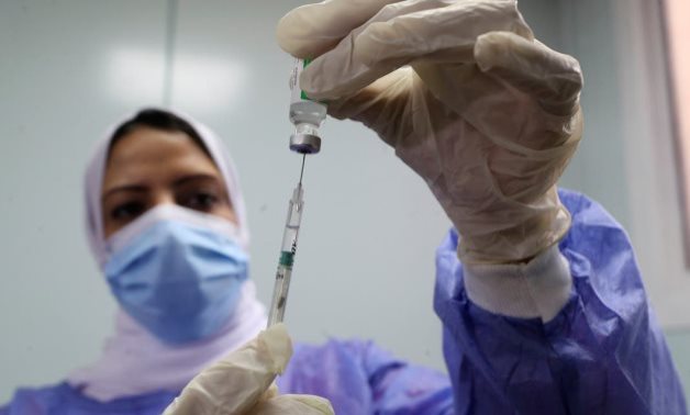 A healthcare worker holds a syringe and vaccine vial against the coronavirus disease (COVID-19) in Cairo, Egypt March 4, 2021. (Reuters)