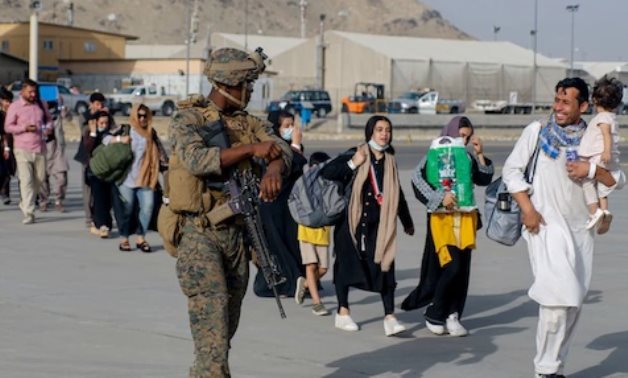 Marines escort evacuees during an evacuation at Hamid Karzai International Airport, Afghanistan, Aug. 18, 2021 -  Press photo from the US Defense Department