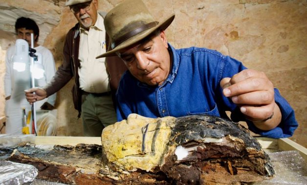Zahi Hawass inspecting an Egyptian artifact - Throomers