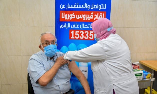 FILE – A medical worker administers a coronavirus vaccine shot to an older citizen – Egyptian Health Ministry