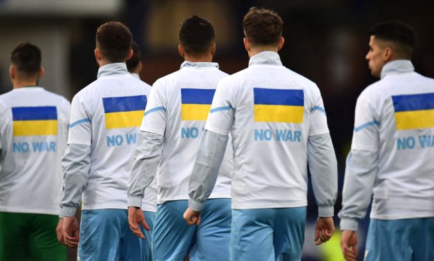 Manchester City players wear t-shirts in support of Ukraine before the match REUTERS/Peter Powell