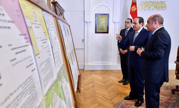 President Abdel Fatah al-Sisi, Prime Minister Mostafa Madbouli (l), and Minister of Justice Omar Marwan (l) checking a map of courts being renovated on April 7, 2022. Press Photo 