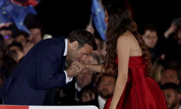 French President Emmanuel Macron kissing Dibani's hand - press photo