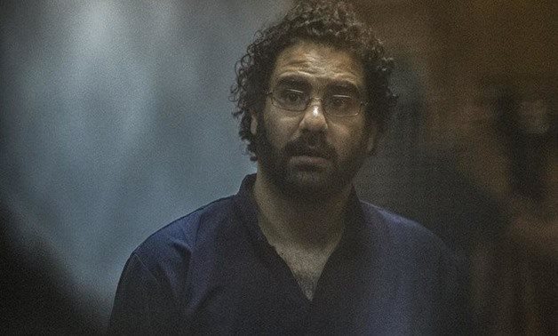 Egyptian activist and blogger Alaa Abdel Fattah looks on from behind the defendant's cage during his trial. (AFP)