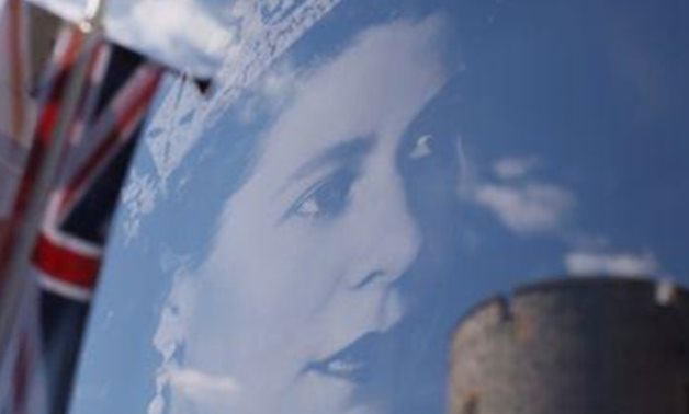 A Union Jack flag outside Windsor Castle is reflected on an image of Britain's Queen Elizabeth, following the death of queen, in Windsor, Britain, September 17, 2022. REUTERS/Andrew Couldridge reuters_tickers