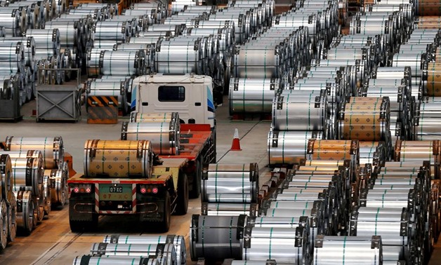 FILE PHOTO: A truck drives past rolls of steel inside the China Steel Corporation factory, in Kaohsiung, southern Taiwan August 26, 2016. REUTERS/Tyrone Siu/File Photo