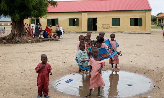 Pupils play in a puddle outside a block of classrooms at Hausari primary school in Michika village, northeast Nigeria June 12, 2017. Picture taken June 12, 2017. REUTERS/Akintunde Akinleye