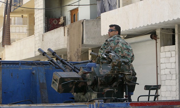 A Free Syrian Army fighter sits on a pick-up truck mounted with anti-aircraft weapon – Muzaffar Salman/Reuters