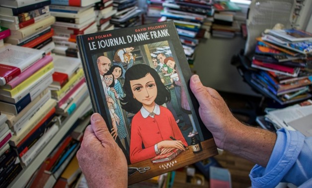 A man holds a copy of the graphic novel version of "The Diary of Anne Frank", by Israeli writer-director Ari Folman and illustrator David Polonsky, in Paris on September 18, 2017
