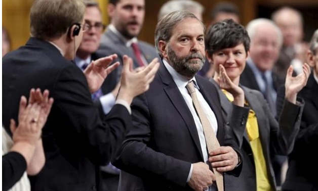 New Democratic Party leader Thomas Mulcair (C) receives a standing ovation from his caucus -REUTERS