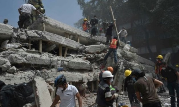 © AFP / by Sofia MISELEM, Sylvain ESTIBAL | Rescuers and volunteers search for survivors amid the rubble and debris of a multistory building flattened by the 7.1-magnitude quake