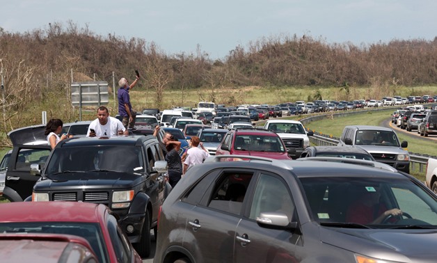 People stop on a highway near a mobile phone antenna tower to check for mobile phone signal, after the area was hit by Hurricane Maria, in Dorado, Puerto Rico September 22, 2017. REUTERS