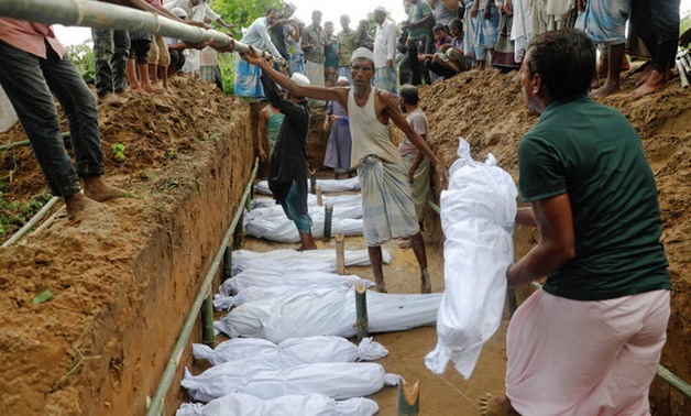 Rohingya refugees, who died after their boat capsized as they were fleeing from Myanmar, are buried in a mass grave just behind Inani beach near Cox's Bazar - REUTERS