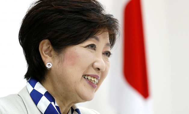 Tokyo Governor Yuriko Koike, head of Japan's Party of Hope, smiles next to a Japanese national flag during an interview with Reuters in Tokyo, Japan October 6, 2017. REUTERS/Issei Kato