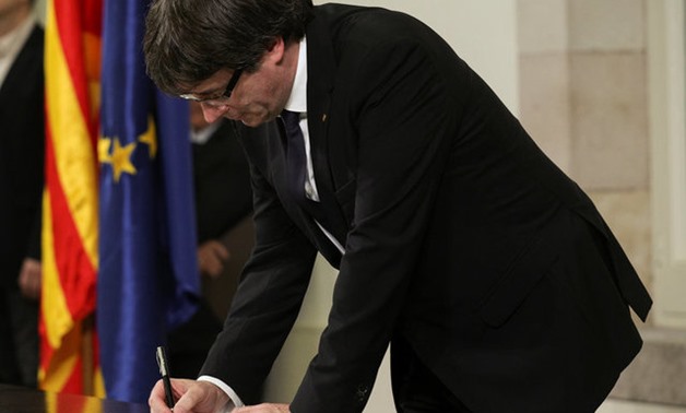 Catalan President Carles Puigdemont signs a declaration of independence at the Catalan regional parliament in Barcelona - REUTERS