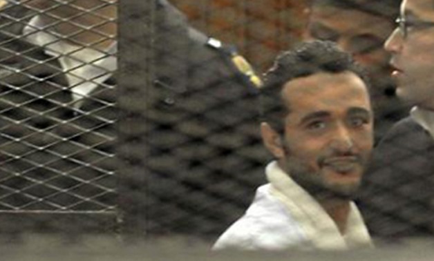 Political activist Ahmed Douma looks on behind bars in Cairo, December 22, 2013 - Reuters