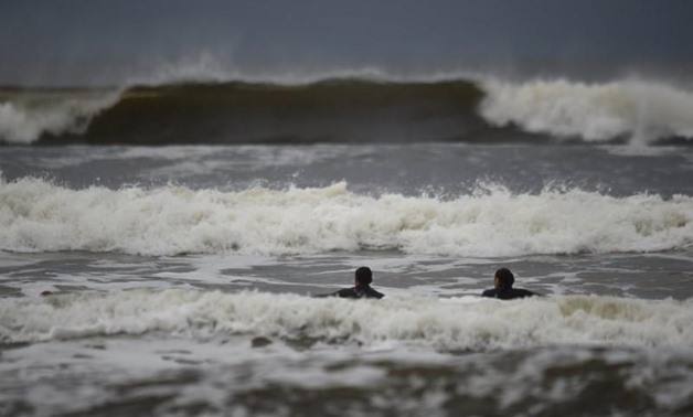 Surfers watch as waves approach in the Atlantic on the eve of storm Ophelia in an area where the tide should be out in the County Clare town of Lahinch, Ireland October 15, 2017. REUTERS/Clodagh Kilcoyne