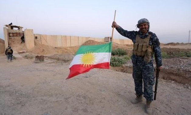 A member of Iraqi federal forces holds the Kurdish flag upside down in Kirkuk, Iraq October 16, 2017. REUTERS/Stringer