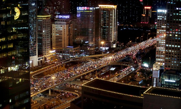 Vehicles are seen through a window as they drive on Guomao Bridge during rush hour in Beijing - REUTERS