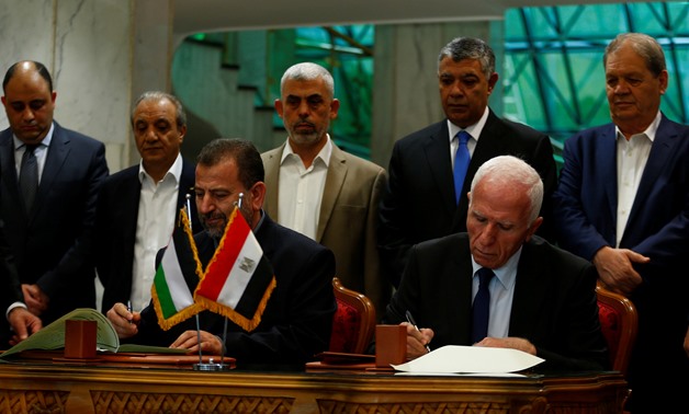 Head of Hamas delegation Saleh Arouri and Fatah leader Azzam Ahmad sign a reconciliation deal in Cairo, Egypt, October 12, 2017. REUTERS- Amr Abdallah Dalsh