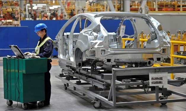 An employee uses a laptop next to a car body at an assembly line at a Ford manufacturing plant in Chongqing municipality April 20, 2012 -
 REUTERS/Stringer