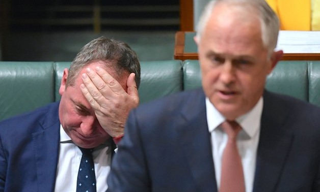 Australian Deputy Prime Minister Barnaby Joyce reacts as he sits behind Australian Prime Minister Malcolm Turnbull in the House of Representatives at Parliament House in Canberra - REUTERS
