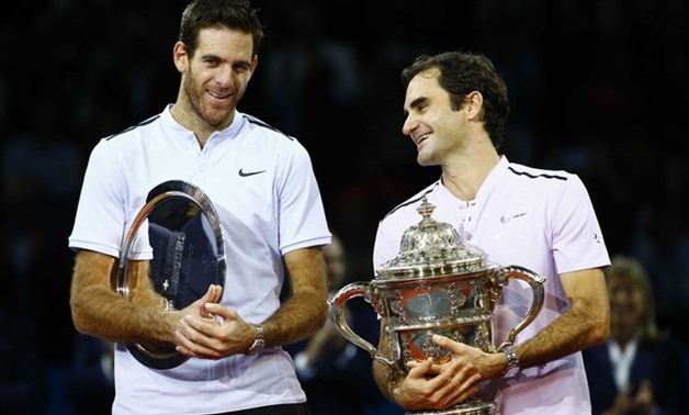 Juan Martin del Potro of Argentina and Roger Federer of Switzerland pose with the trophies after the final match. REUTERS