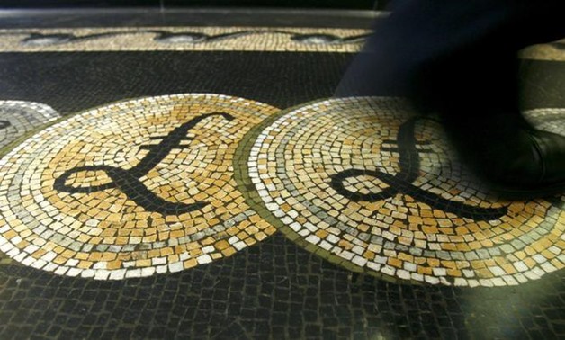 An employee is seen walking over a mosaic of pound sterling symbols set in the floor of the front hall of the Bank of England in London -
 REUTERS/Luke MacGregor