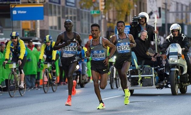 Runners Ghirmay Ghebreslassie (C), of Eritrea, Lucas Rotich (L), of Kenya, and Lelisa Desisa, of Ethiopia run in the TCS New York City Marathon - AFP