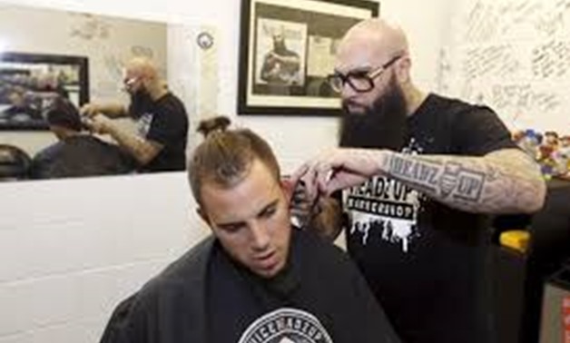 Hugo 'Juice' Tandron gives a haircut to Miami Marlins starting pitcher Jose Fernandez in his barber shop in Marlins Park in Miami, Florida - REUTERS/Joe Skipper