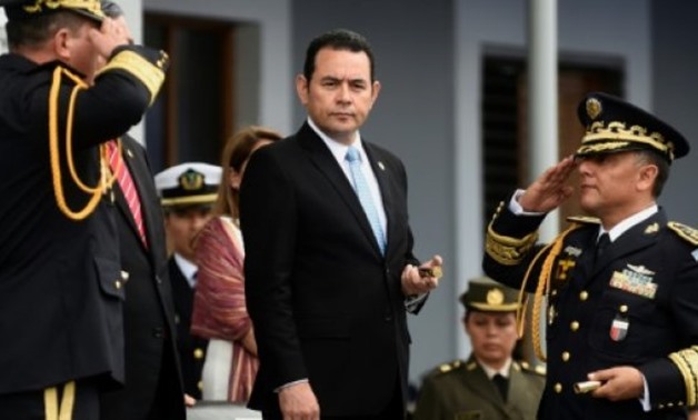 Guatemalan President Jimmy Morales (C), seen here at the swearing in last month of new Defense Minister Luis Ralda (L), is the target of street protests demanding he resign