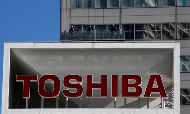The logo of Toshiba Corp is seen as window cleaners work on the company's headquarters in Tokyo, Japan, February 14, 2017. REUTERS/Toru Hanai