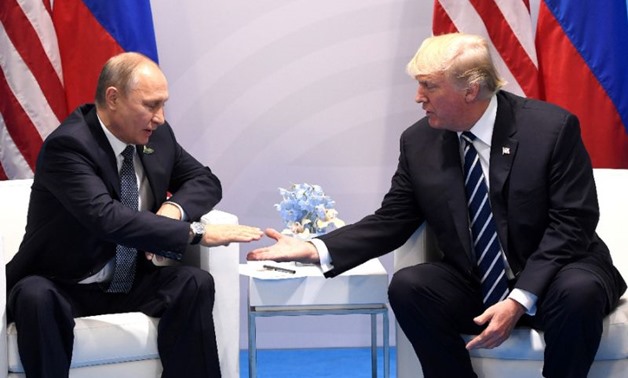 U.S. President Donald Trump and Russia's President Vladimir Putin shake hands at their first meeting, held on the sidelines of the G20 summit in Germany. AFP/Saul Loeb