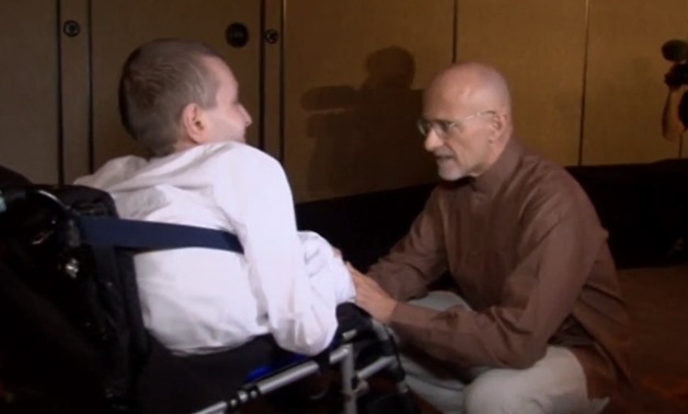 Italian doctor Sergio Canavero talks with a disabled patient - Screenshot from Reuters's video