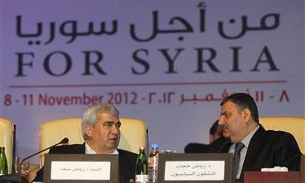 Leading Syrian dissident Riad Seif (L) speaks with former Syrian Prime Minister Riyad Hijab- Reuters