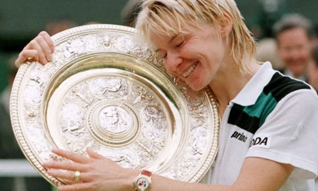 Jana Novotna of the Czech Republic hugs the winner's trophy after victory over Nathalie Tauziat of France in the Women's Singles final at the Wimbledon Tennis Championships July 4. Novotna won the match 6-4 7-6 (7-2)./File Photo
