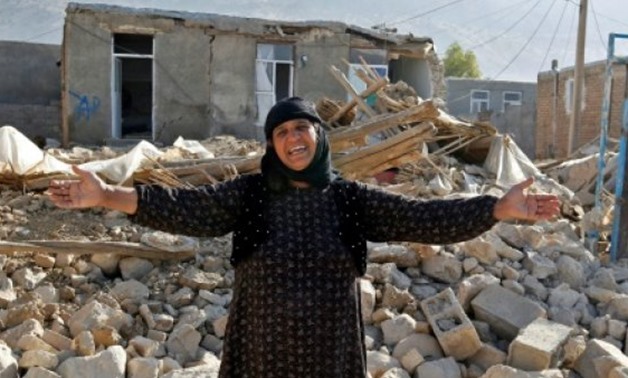 © AFP | An Iranian woman crying for help next to the rubble of her home in Kouik village in the western province of Kermanshah, two days after a 7.3-magnitude quake killed hundreds and injured thousands