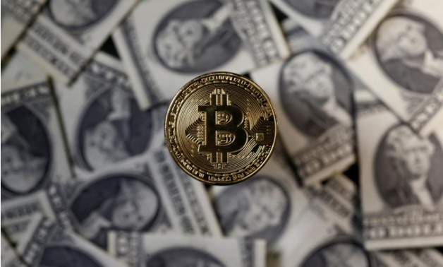  A bitcoin (virtual currency) coin placed on Dollar banknotes is seen in this illustration picture, November 6, 2017 - REUTERS/Dado Ruvic/Illustration