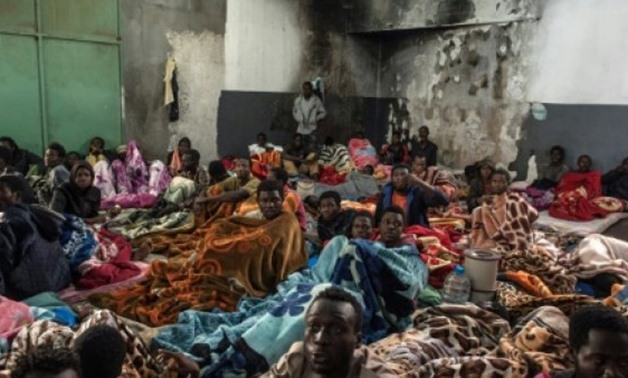 © AFP/File | African migrants sit in a packed room with their beds and blankets, at the Tariq Al-Matar detention centre on the outskirts of the Libyan capital Tripoli
