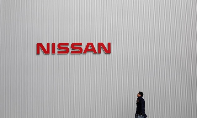 FILE PHOTO: A man walks under the logo of Nissan Motor Co at the company's showroom in Yokohama, south of Tokyo February 8, 2013. REUTERS/Toru Hanai/File Photo