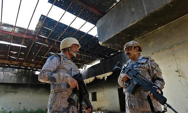 Saudi border guards stand inside a building which was reportedly hit in shelling by Yemeni Huthi rebels in the al-Khubah area in the southern Jizan province, near the border with Yemen on October 3, 2017

