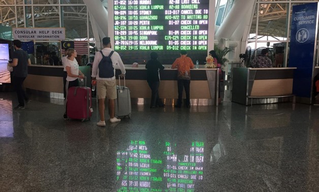 International passengers are seen near the flight information board at Ngurah Rai Bali International Airport, Kuta, Bali, Indonesia December 2, 2017. REUTERS/Kanupriya Kapoor