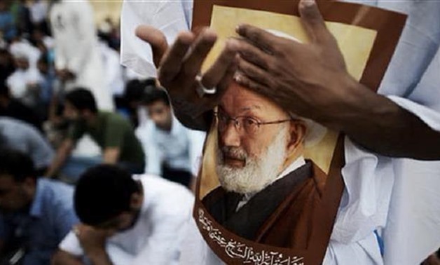Bahraini demonstrators protest against the revocation of the citizenship of top Shiite cleric Sheikh Isa Qassim (portrait), near Qassim's house near Manama on June 20, 2016 - AFP
